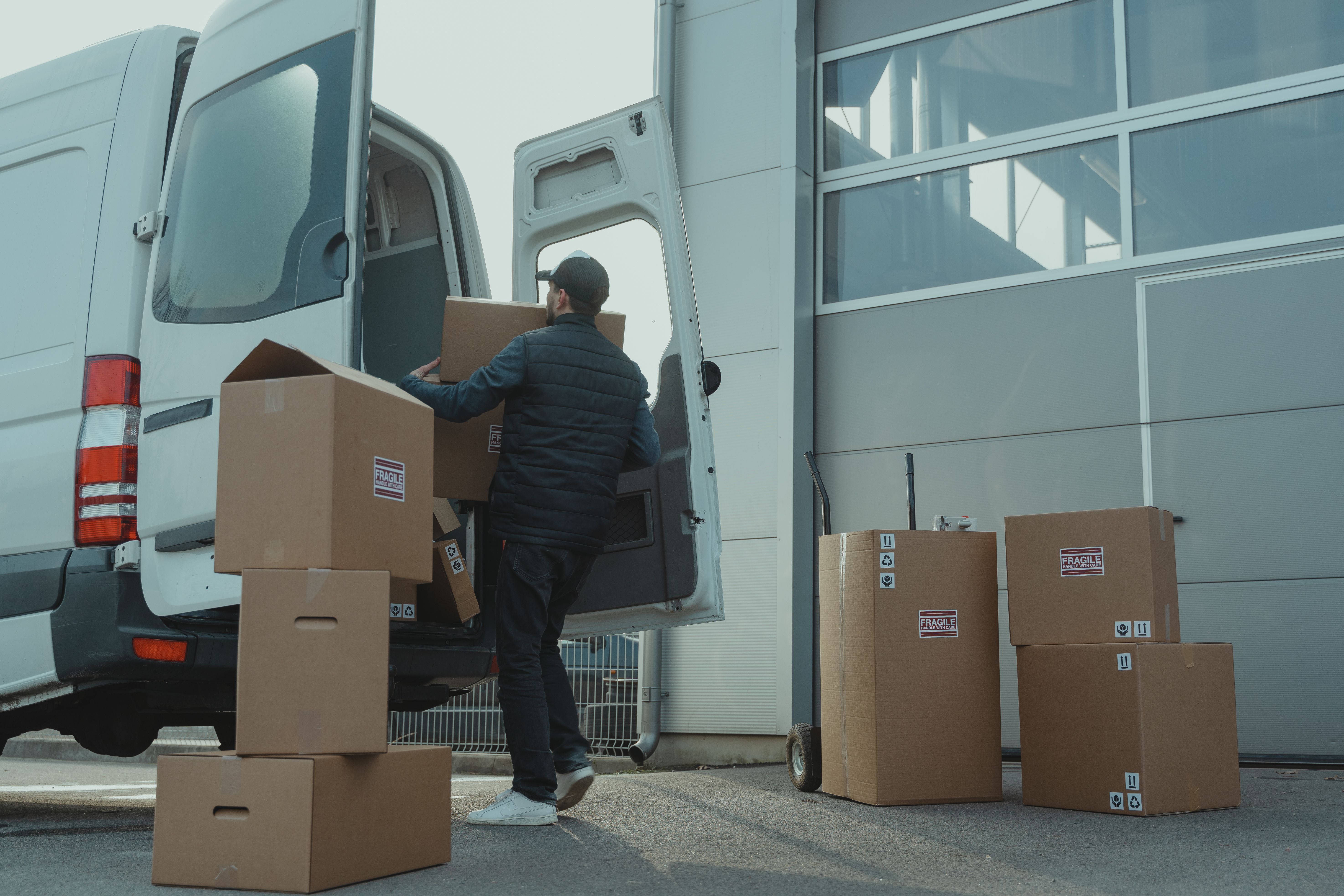 A man packing a truck with construction materials in cardboard boxes.